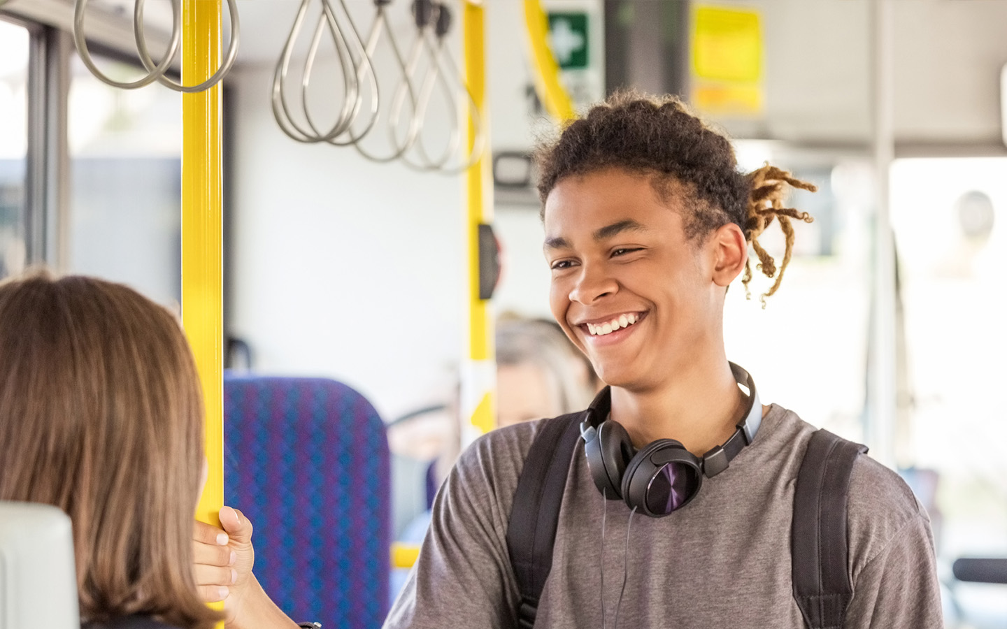 Male College Student Smiling on a Bus