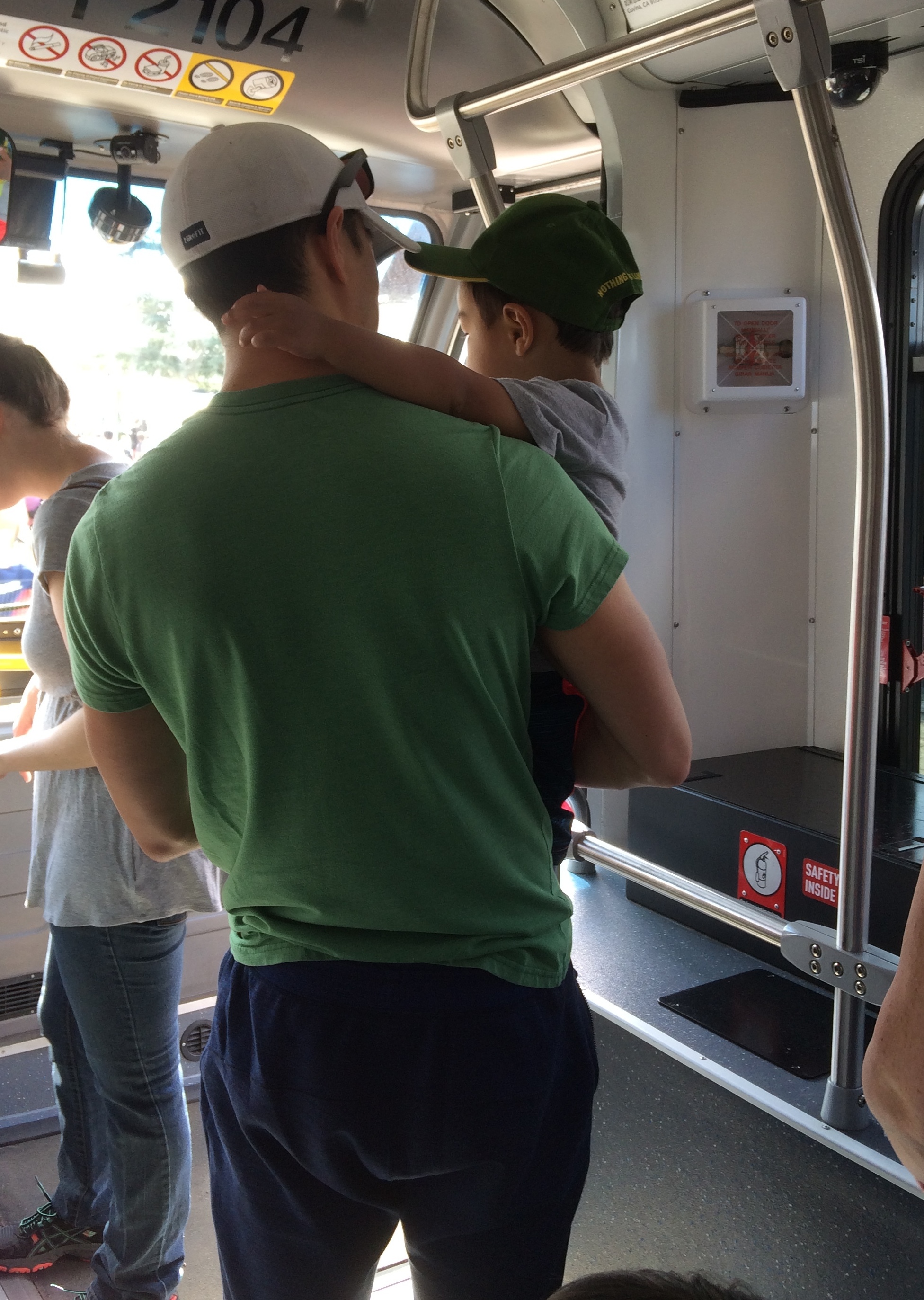 a parent holds a child on a bus