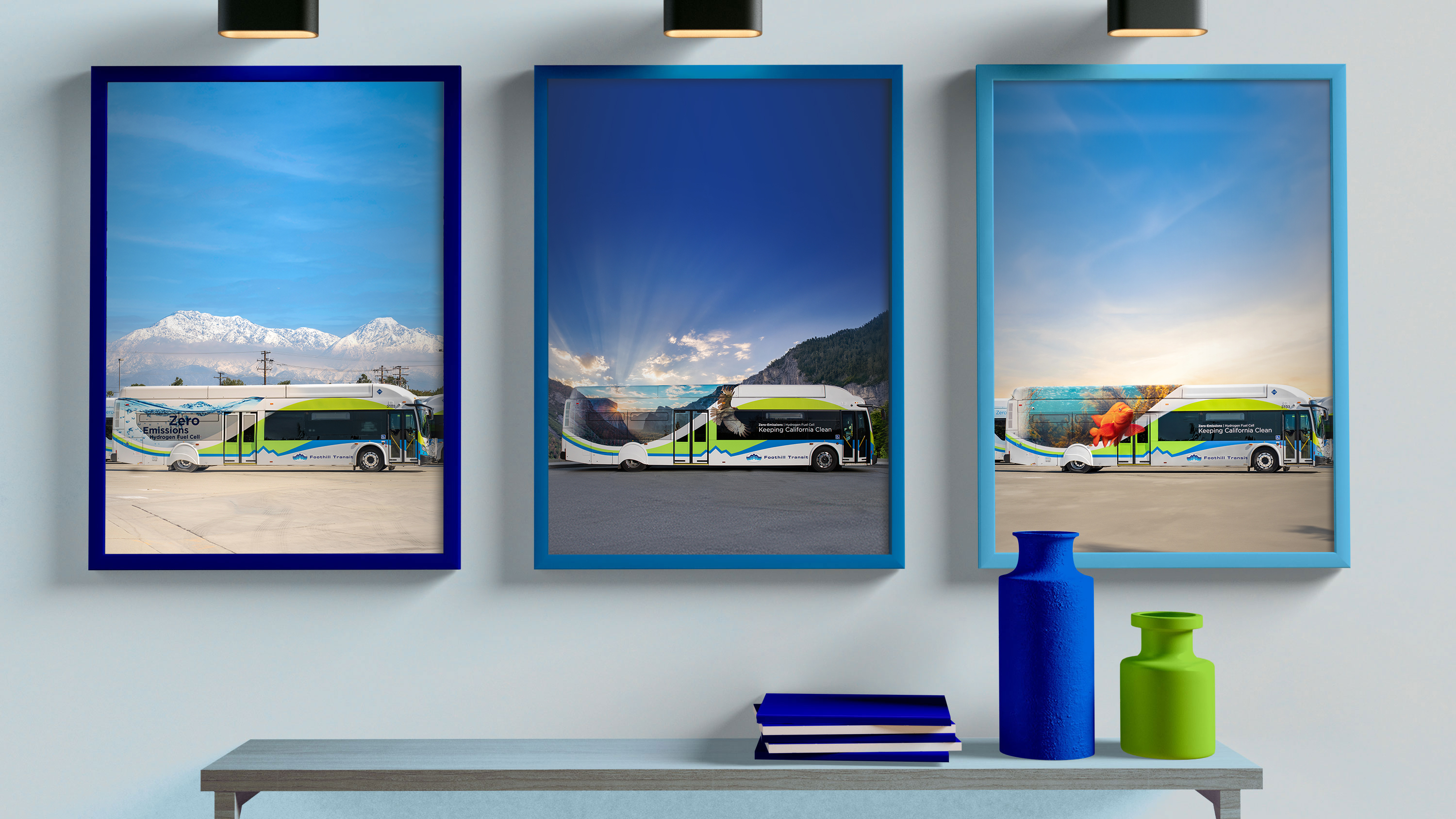 framed photos of Foothill Transit buses on a wall under lights and over a shelf with books and vases