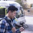 customer looks at phone in front of bus