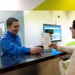 A customer service representative helps a customer in a transit store.