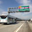 Line 495 bus on the 10 Freeway under a sign that says "Express Lanes Entrance"