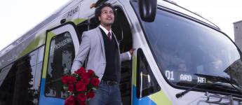 El cliente sonriente se baja del autobús con rosas.