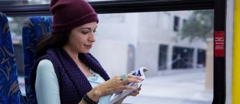 A customer reads a book on the bus