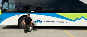 Thundra and her handler Martin pose in front of a Foothill Transit bus