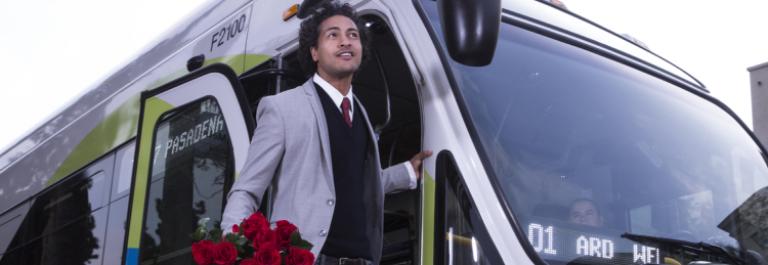 El cliente sonriente se baja del autobús con rosas.