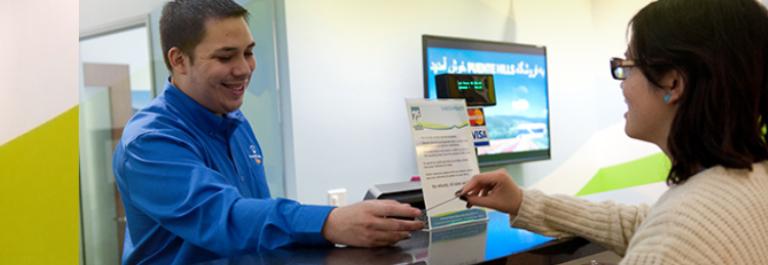A customer service representative helps a customer in a transit store.