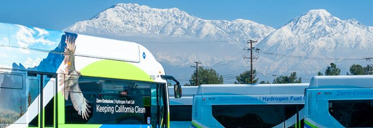 Hydrogen Fuel Cell buses in front of snowy mountains