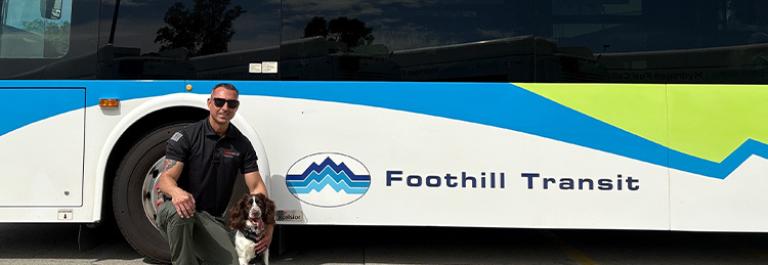 Thundra and her handler Martin pose in front of a Foothill Transit bus